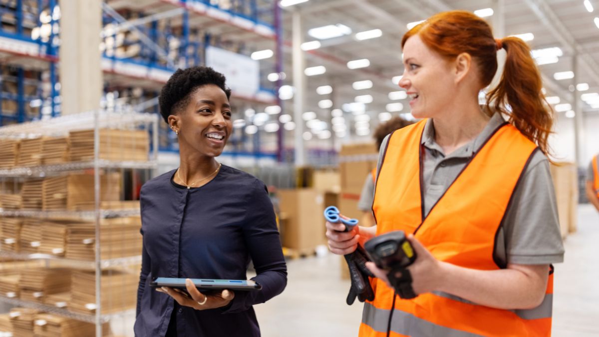 two women talking in a warehouse