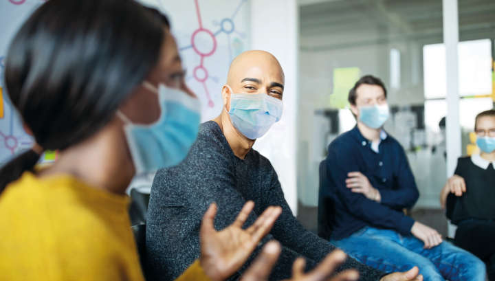 People having a meeting in masks