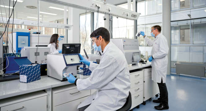 QIAstat-Dx, QIAcuity, syndromic testing, digital PCR, dPCR, scan cartridge, Labworker handling the instrument, touch display, Julian Phillips, Amit Singh, Chaimae Safi, mask, wearing masks, labcoat