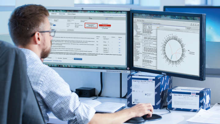 Scientist in front of two computer sreens