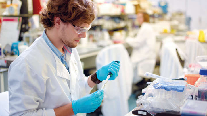 Young male Scientist using micro pipette with DNA