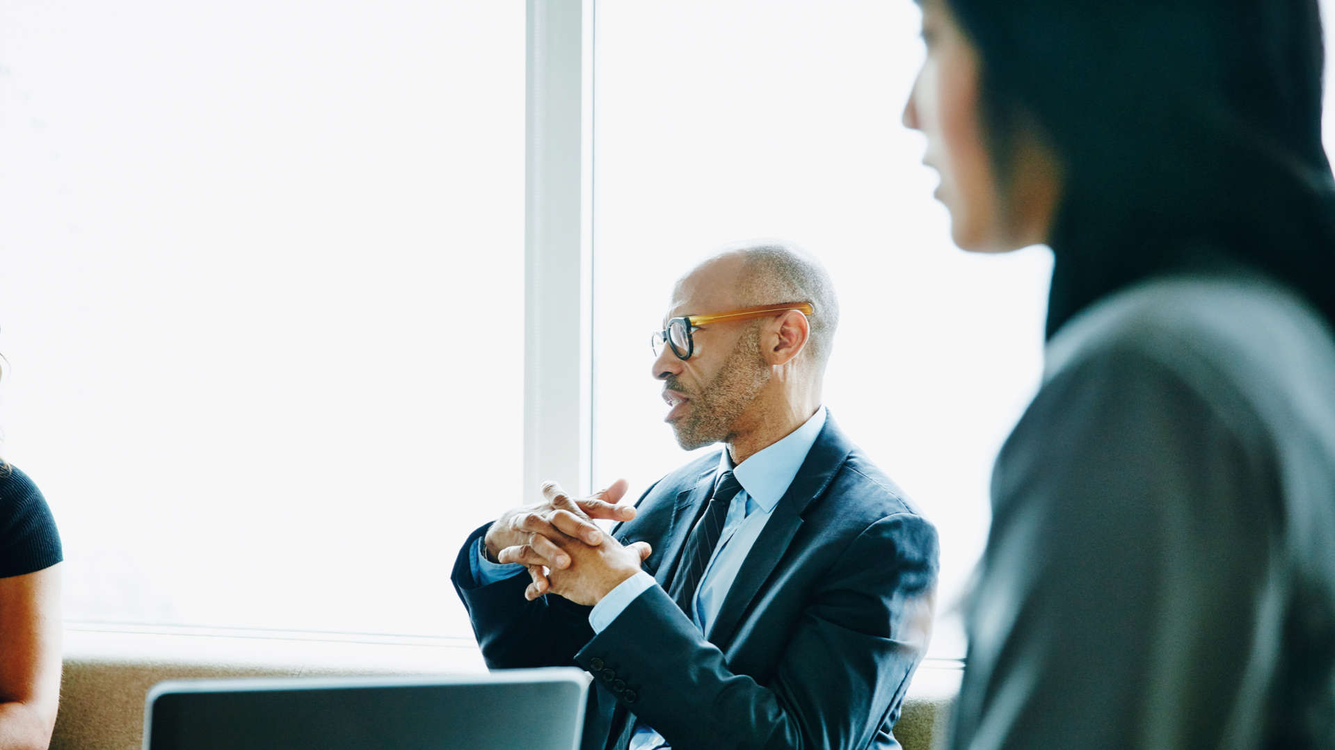 Mature businessman discussing project with colleague during meeting in offic