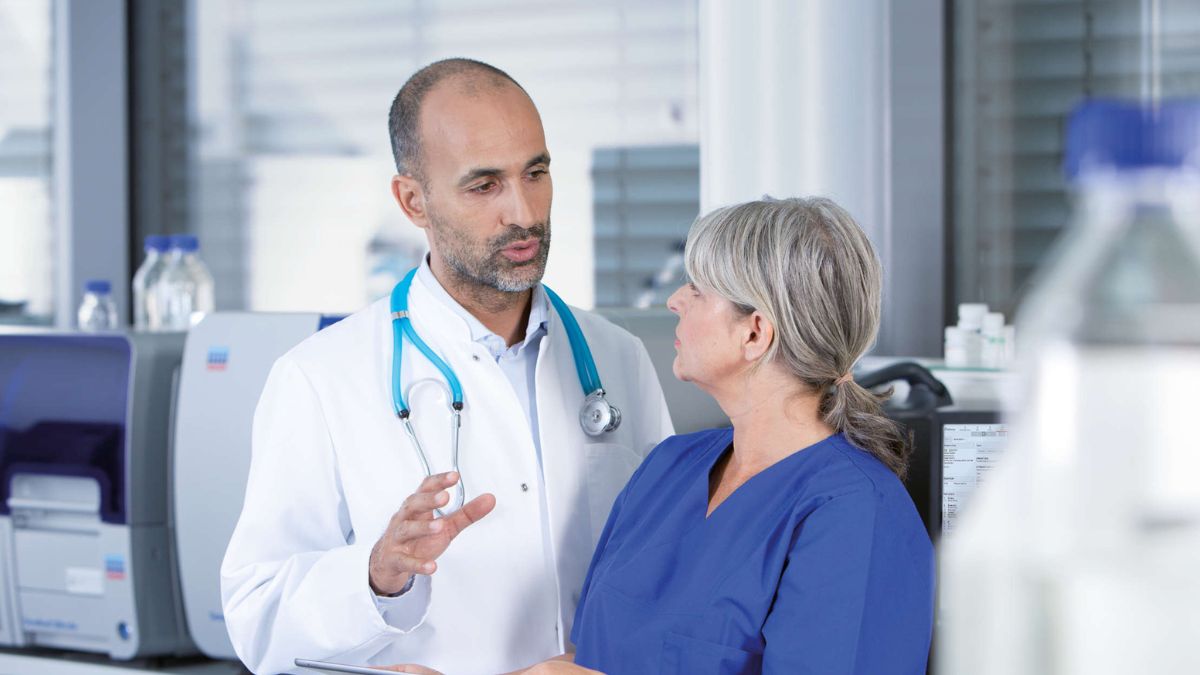 Male scientist (doctor) and female pathologist discussing data