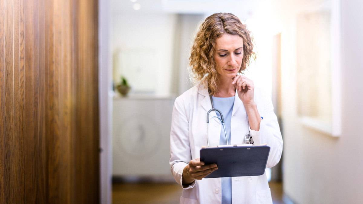 Female doctor looking at clipboard with test results