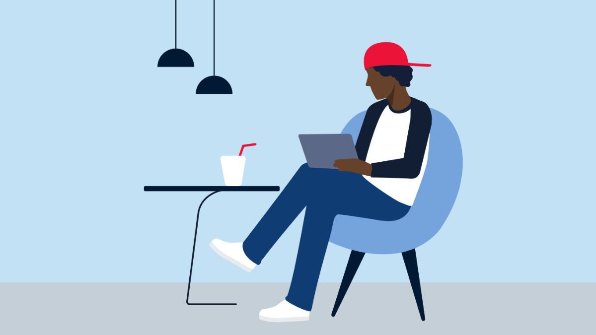 a man sitting in an armchair at a table and reading