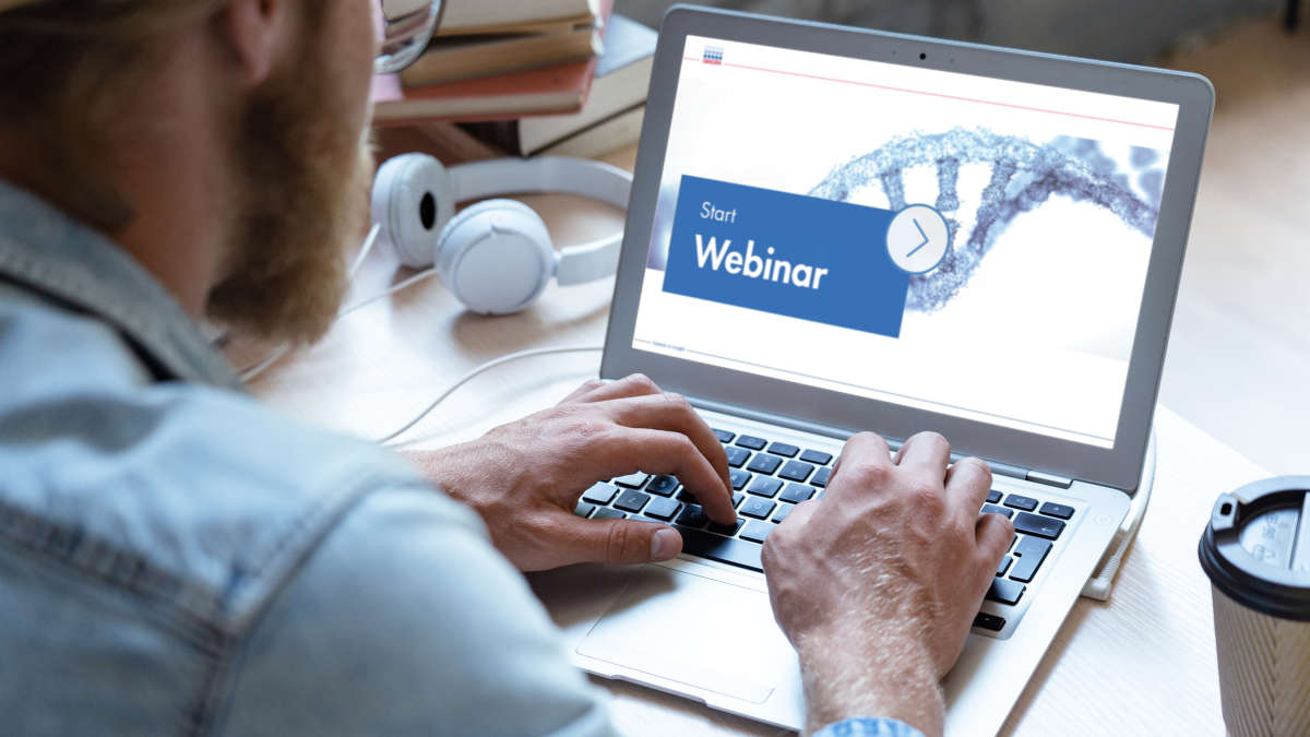 male person sitting in an office watching a webinar, labtop, screen, work on comuter
